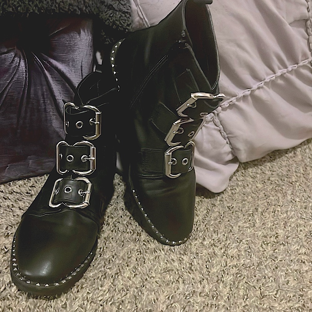 Black Leather ankle boots with adjustable buckles and zippers outlined by studs.